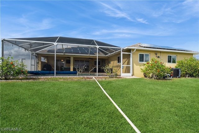 back of property featuring central AC, glass enclosure, and a lawn