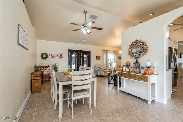 tiled dining space with ceiling fan and vaulted ceiling