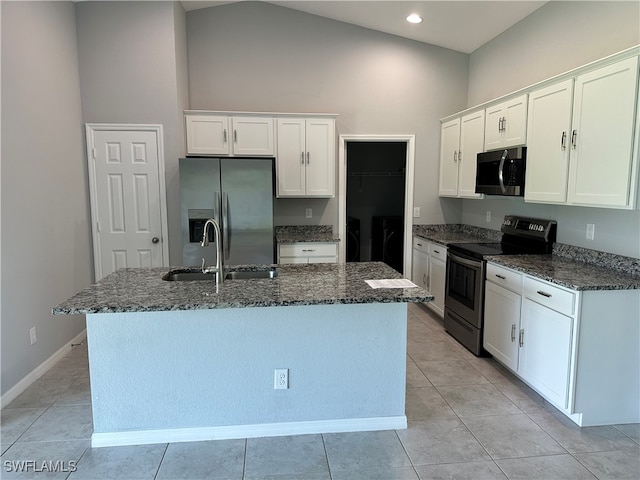 kitchen with white cabinets, a kitchen island with sink, high vaulted ceiling, dark stone counters, and stainless steel appliances