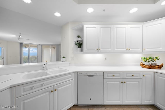 kitchen with white dishwasher, sink, light tile patterned floors, white cabinetry, and kitchen peninsula