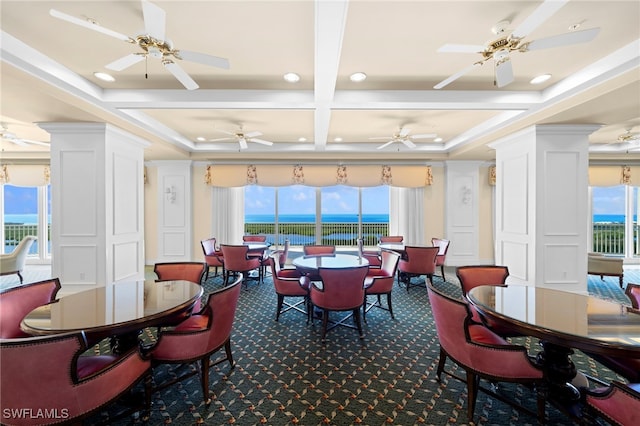 carpeted dining space featuring a water view, plenty of natural light, and coffered ceiling