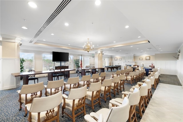 carpeted dining area featuring a raised ceiling, ornamental molding, and an inviting chandelier