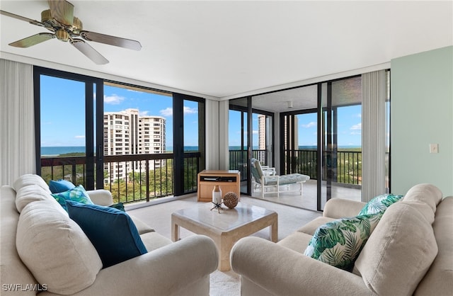 carpeted living room with floor to ceiling windows and ceiling fan