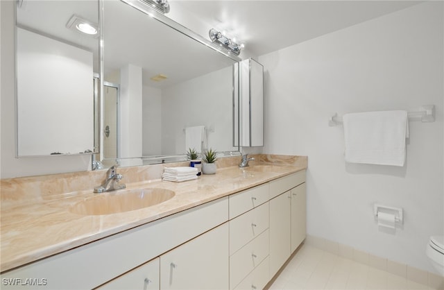 bathroom featuring tile patterned flooring, vanity, toilet, and walk in shower