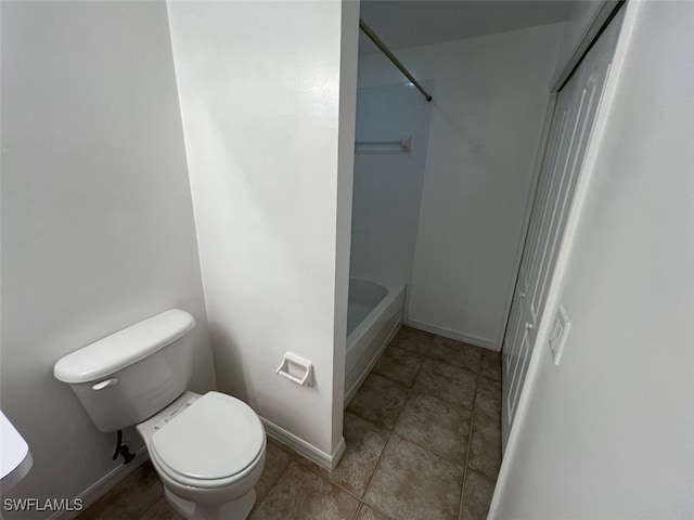 bathroom with toilet, washtub / shower combination, and tile patterned flooring