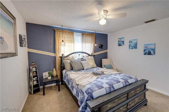 bedroom featuring ceiling fan, a textured ceiling, and light carpet