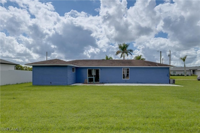 rear view of property featuring a lawn