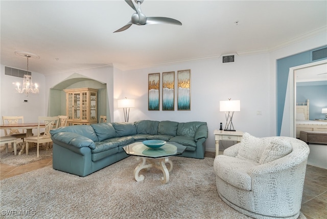 living room featuring ceiling fan with notable chandelier, tile patterned flooring, and crown molding