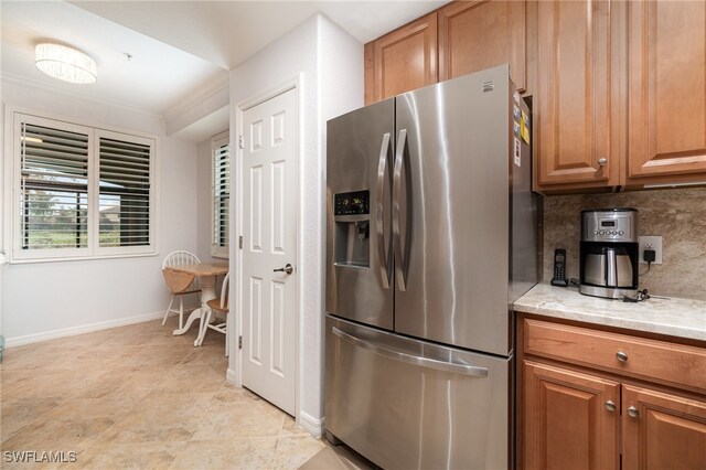 kitchen with crown molding, backsplash, and stainless steel fridge with ice dispenser