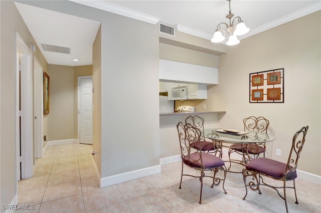 dining room featuring crown molding, an inviting chandelier, and light tile patterned floors