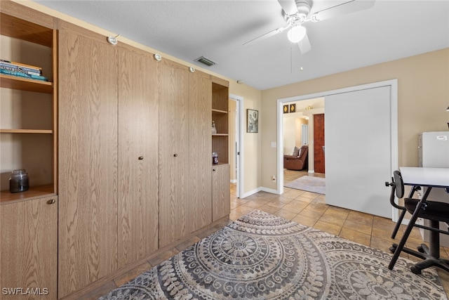 interior space with white refrigerator and ceiling fan