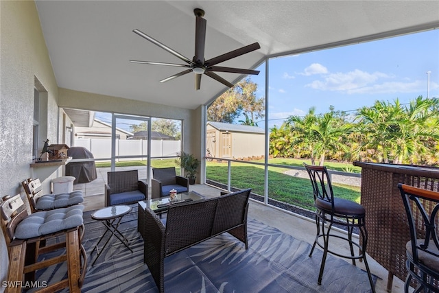 sunroom featuring ceiling fan and lofted ceiling