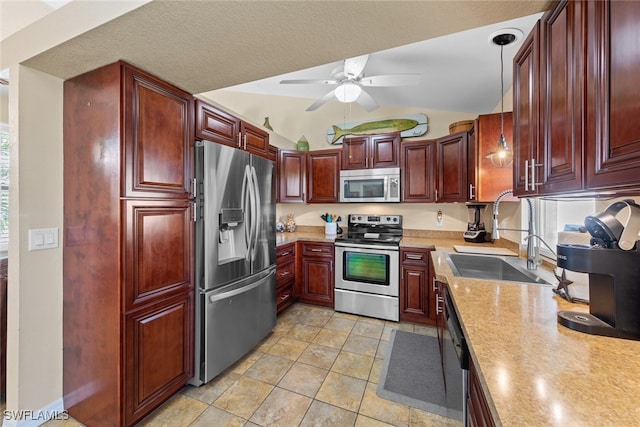 kitchen with appliances with stainless steel finishes, vaulted ceiling, ceiling fan, sink, and decorative light fixtures