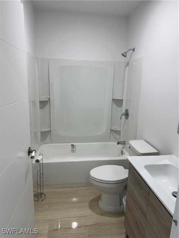 full bathroom featuring toilet, hardwood / wood-style floors, vanity, and bathing tub / shower combination