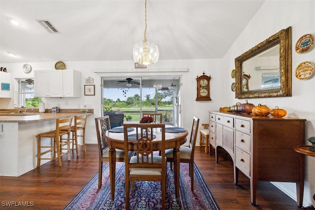 dining area with ceiling fan with notable chandelier, dark wood-type flooring, sink, and lofted ceiling