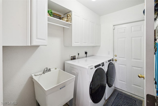 laundry area with cabinets, separate washer and dryer, and sink