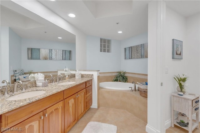 bathroom with tile patterned floors, vanity, and tiled tub