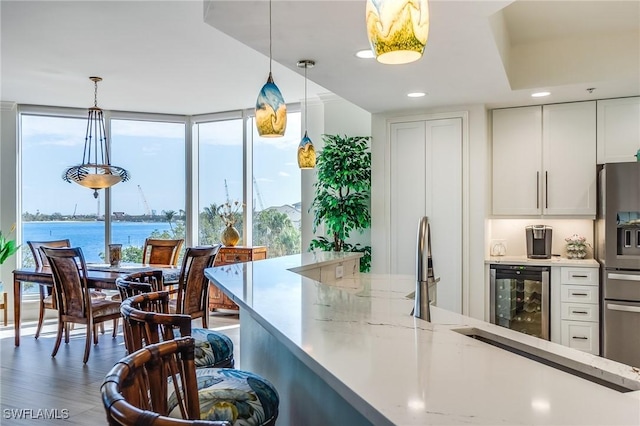 kitchen featuring stainless steel refrigerator with ice dispenser, dark hardwood / wood-style flooring, a water view, white cabinetry, and wine cooler