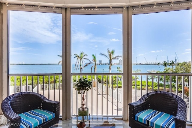 sunroom / solarium featuring a healthy amount of sunlight and a water view