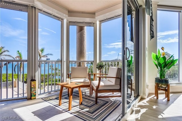 sunroom featuring a water view