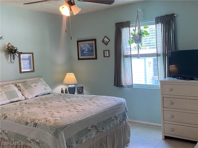 bedroom with ceiling fan, a textured ceiling, and light tile patterned floors