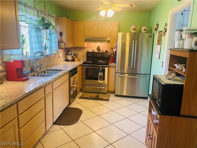 kitchen featuring light stone countertops, appliances with stainless steel finishes, sink, backsplash, and ceiling fan