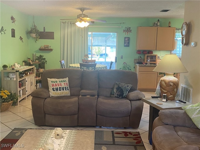 tiled living room featuring ceiling fan and a textured ceiling