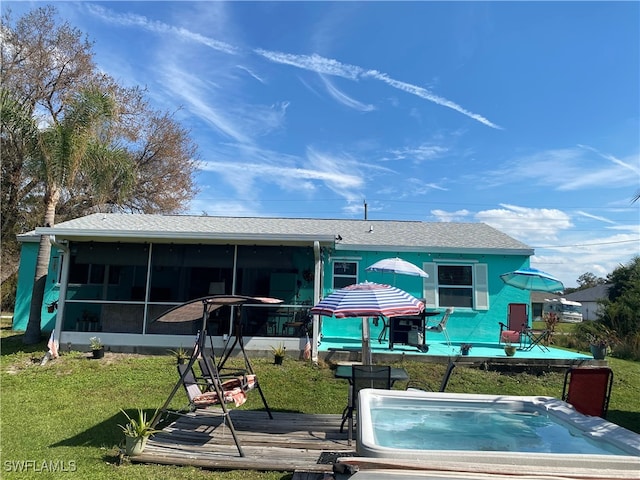 back of property featuring a yard and a sunroom