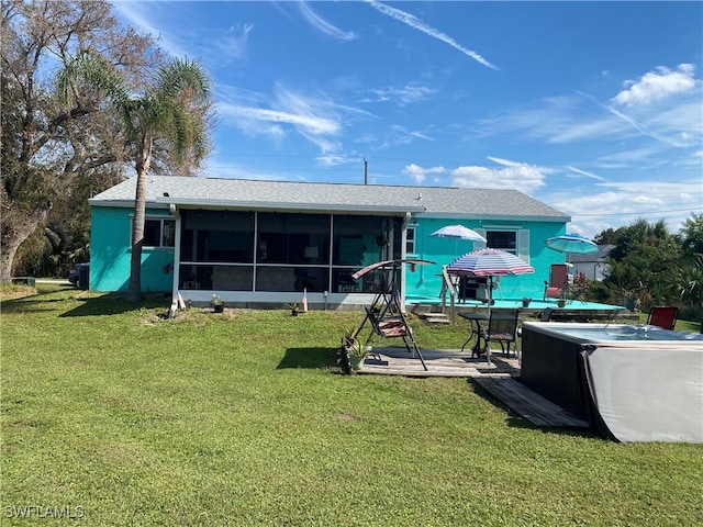 back of house featuring a patio area, a yard, and a sunroom