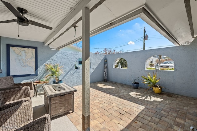 view of patio / terrace with ceiling fan and a fire pit