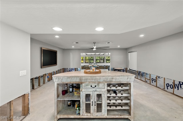 dining space featuring a textured ceiling, bar area, and ceiling fan