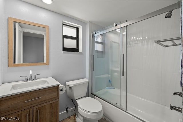 full bathroom with vanity, toilet, and bath / shower combo with glass door