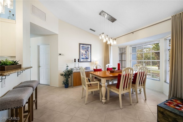 dining area with vaulted ceiling, a notable chandelier, and light tile patterned floors