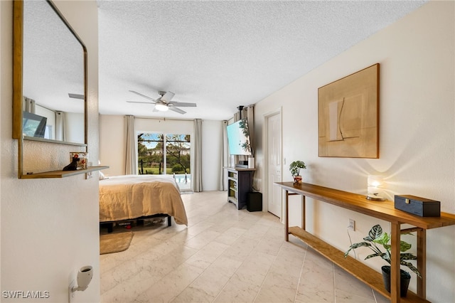 bedroom with ceiling fan and a textured ceiling