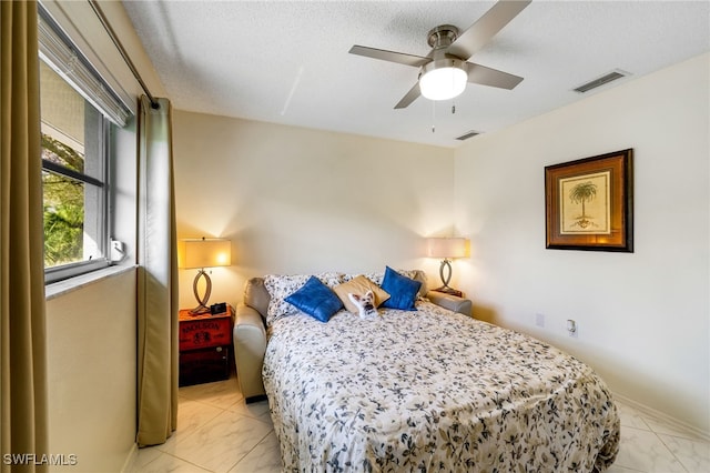 bedroom featuring ceiling fan and a textured ceiling