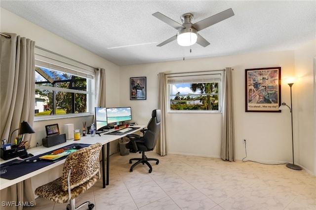 home office featuring a textured ceiling, a healthy amount of sunlight, built in desk, and ceiling fan