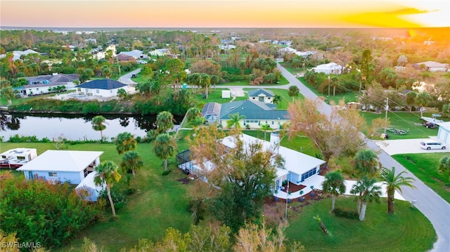 aerial view at dusk featuring a water view