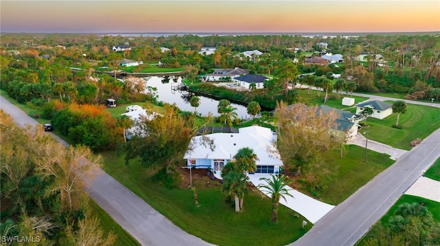 aerial view at dusk featuring a water view