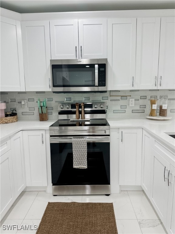 kitchen with decorative backsplash, white cabinetry, and stainless steel appliances