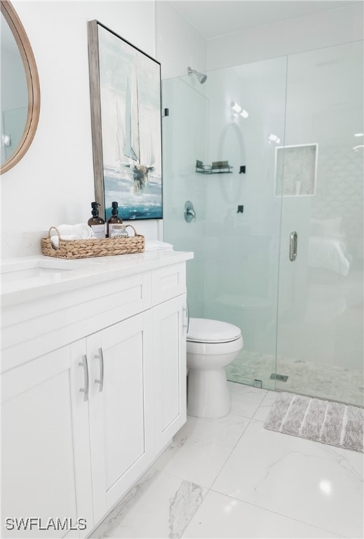 bathroom with a shower with door, vanity, and toilet