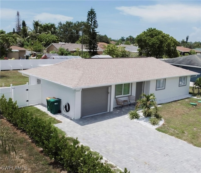 ranch-style home featuring a front lawn and a garage