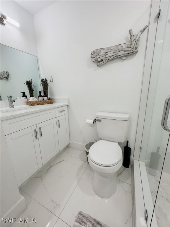 bathroom with vanity, toilet, and a shower with shower door