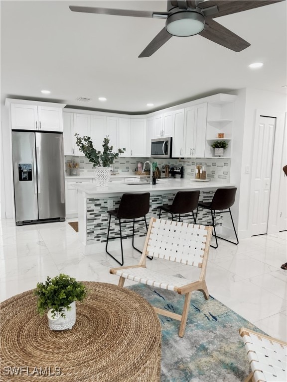 kitchen featuring sink, white cabinetry, stainless steel appliances, and tasteful backsplash