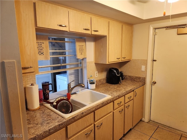 kitchen featuring light tile patterned floors, sink, light brown cabinetry, and tasteful backsplash