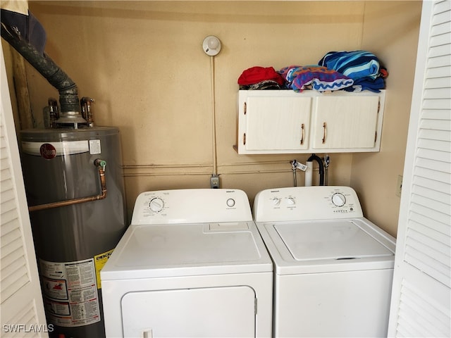 clothes washing area featuring cabinets, gas water heater, and independent washer and dryer