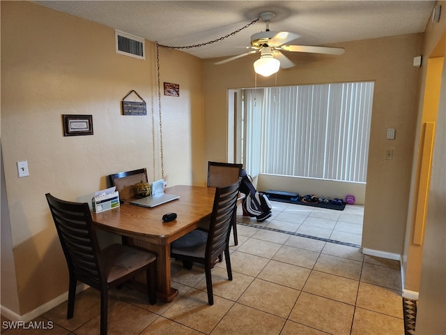 tiled dining area featuring ceiling fan and a textured ceiling