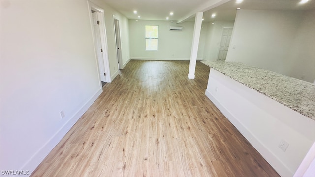 interior space with an AC wall unit and light hardwood / wood-style floors