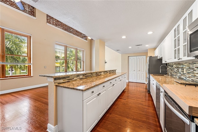 kitchen featuring white cabinetry, backsplash, and hardwood / wood-style flooring