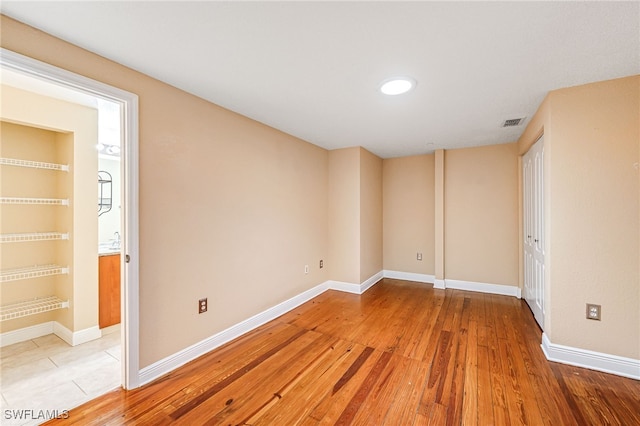 2260 First St Unit 207, Fort Myers, FL 33901 - unfurnished bedroom with baseboards, light wood-style flooring, and ensuite bathroom