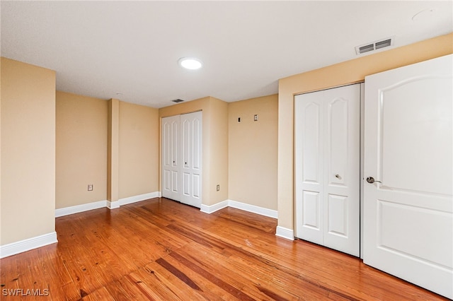 2260 First St Unit 207, Fort Myers, FL 33901 - unfurnished bedroom featuring multiple closets, light wood-style flooring, baseboards, and recessed lighting